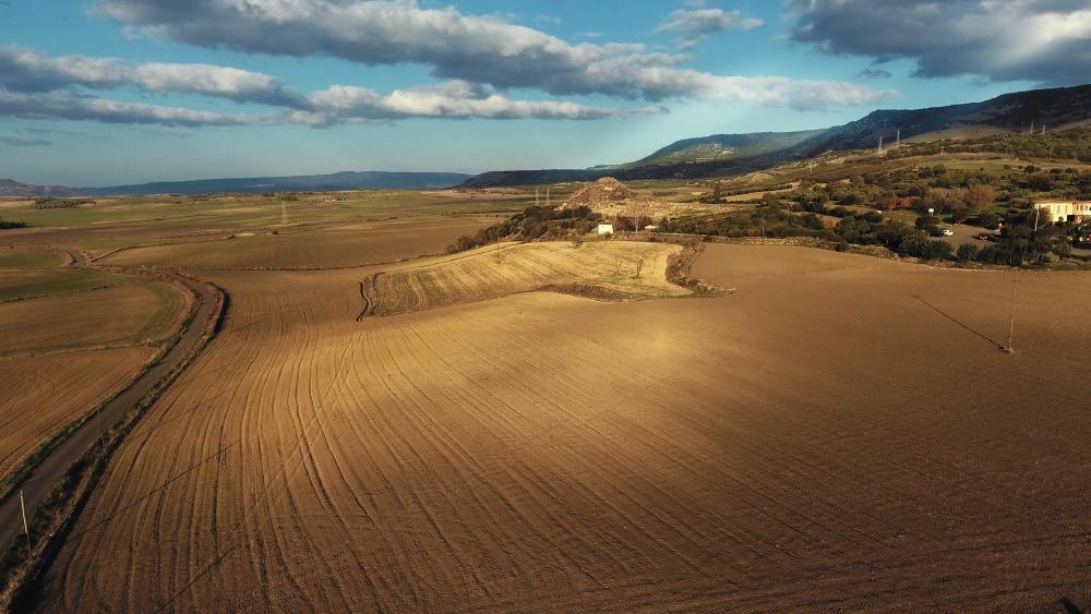 1 - Nuraghe di Barumini wide shot with wheat fields